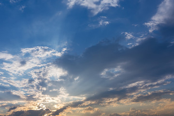 Obraz premium light of sunbeam on sunset sky background with clouds