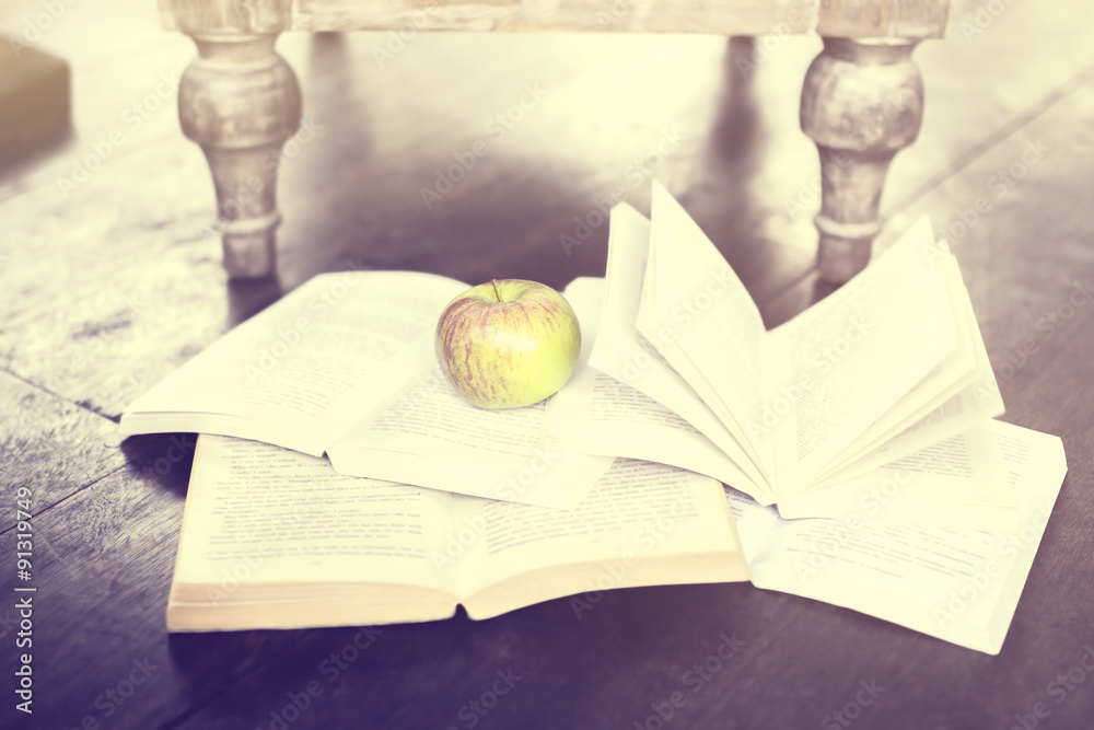 Poster some books and an apple on the floor