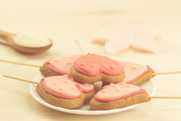 delicious fresh cookies on a white plate in the form of heart on a wooden background.