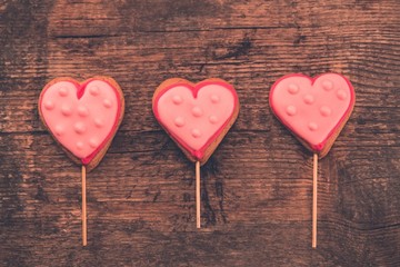 Delicious fresh cookies in the shape of a heart on a wooden background.