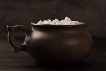 fresh tasty cottage cheese on a plate on wooden background. Homemade, curd