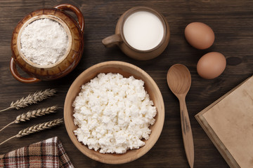 fresh tasty curd in pot on wooden background. Homemade, cottage cheese