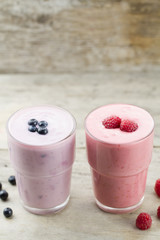 Raspberry and blueberry smoothie with berries on wooden background. Healthy vegetarian food, diet.
