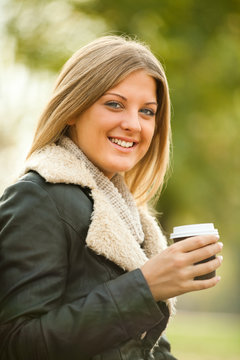 Young woman drinking coffee to go
