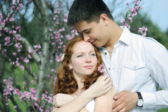 beautiful young couple in love among the flowering trees