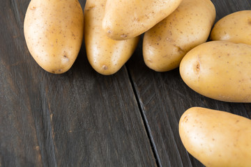 fresh potatoes on wood background