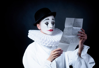 Sad mime Pierrot reading the love letter