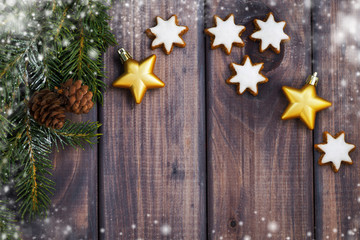 dark wooden background with fir branches, cookies and decoration