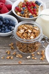 jar with homemade granola, milk and fresh berries, vertical