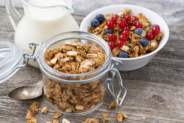 jar with homemade granola, milk and fresh berries