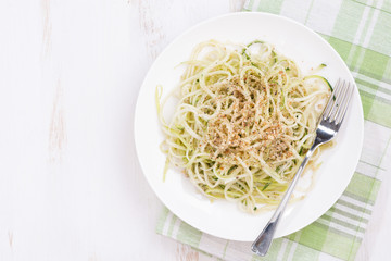 Vegetarian pasta with zucchini and nuts, top view