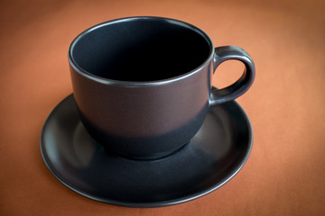 Cup of coffee on brown background