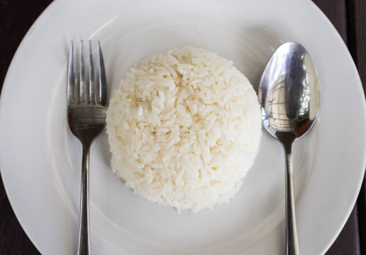 Cooked rice on the dish with spoon and fork