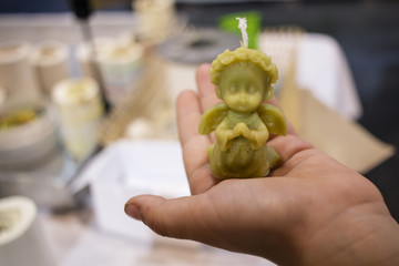 Little bees-wax angle in a hand of a child