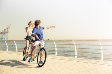 Couple riding on tandem bicycle outdoors