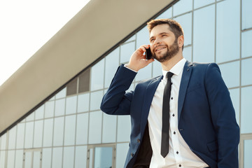 Young businessman talking on his phone outdoors