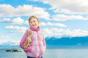 Outdoor portrait of adorable little girl playing by the lake