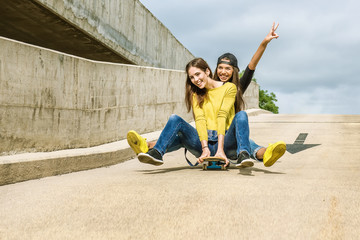 Skateboarder girlfriends roll down the slope