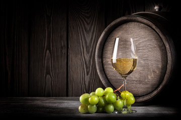 Glass white wine and bunch grapes