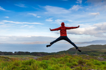 Man jumping on the top pf a mountain, Skye, Scotland - 91332305