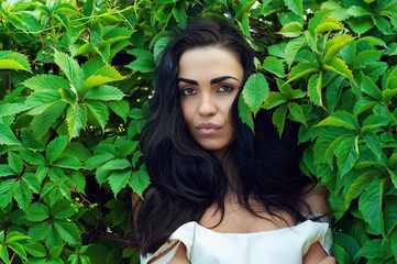 brunette in green leaves