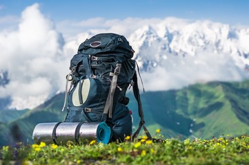 Fototapeta Tourist backpack and sleeping pad on a background of mountains obraz