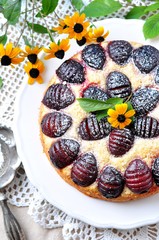 Organic plum cake with powdered sugar on a white background