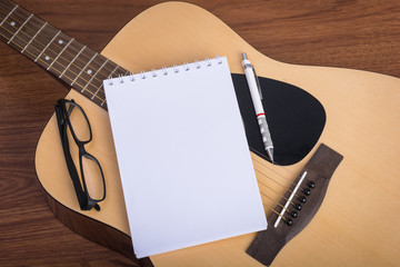 guitar notebook, pencil and eyeglasses