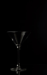 Empty martini glass on a black background..