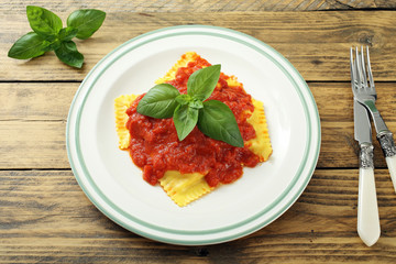 top view ravioli con pomodoro e basilico su tavolo legno rustico