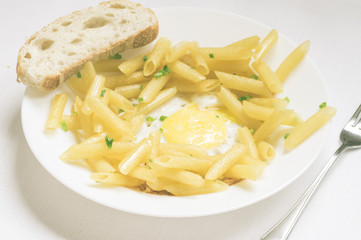 Penne pasta with fresh herbs and fried eggs