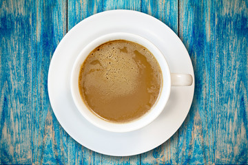 Cup of coffee on blue wooden surface
