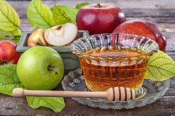 apples with a bowl with honey on the old wooden table