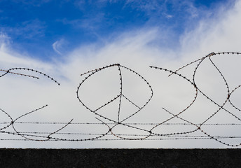 CND Symbol Peace aus Stacheldraht vor Himmel nach Unwetter