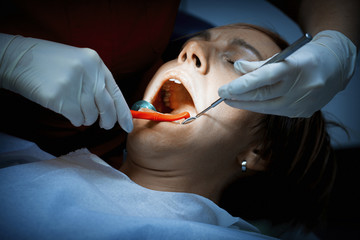 Dentist examining a patients teeth at the dental clinic.