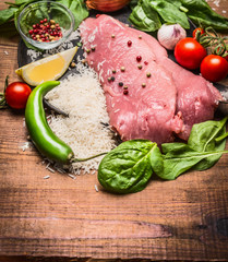 fresh raw steak of turkey with vegetables with rice and vegetables and spices on wooden rustic background close up