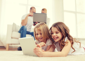 smiling sister with tablet pc and parents on back