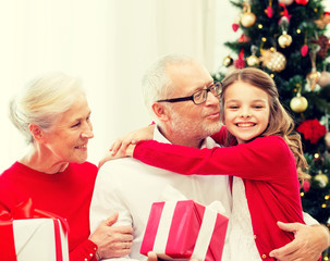 Obraz na płótnie Canvas smiling family with gifts at home