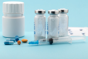 Colorful pills bottle and injection syringe