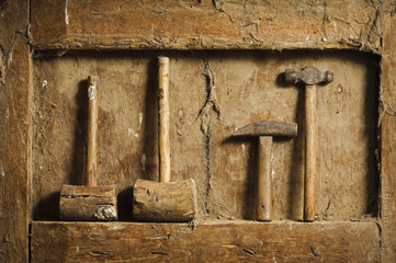 old wooden and metallic  hammers tools on antique wooden panel