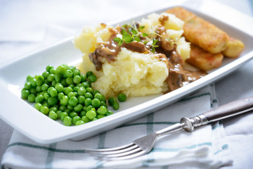 Veganer Kartoffelstampf mit Erbsen und Gemüsestäbchen