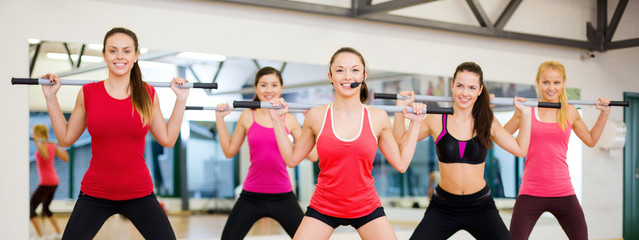 group of smiling people working out with barbells