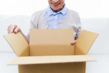 close up of senior woman with parcel box at home