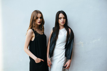 Two beautiful friends pose on white background