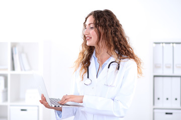 Friendly smiling young female doctor, isolated over white background