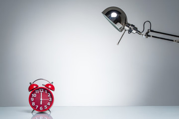 lighting up red alarm clock with desk lamp