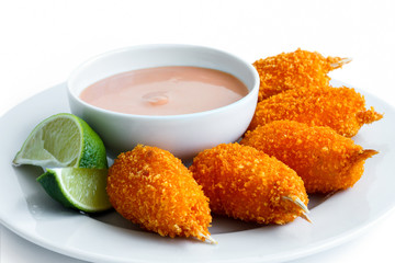 Plate of fried breaded surimi crab claws with bowl of pink sauce © Moving Moment