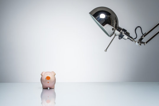 Lighting Up Pink Piggy Bank With Desk Lamp