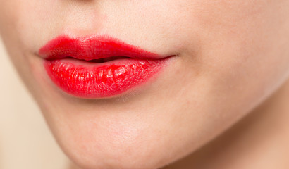 Fototapeta premium Close-up shot of woman lips with glossy red lipstick