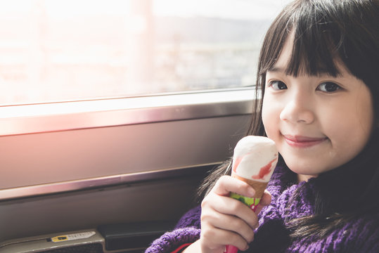 Little asian girl smiling  and eating ice cream